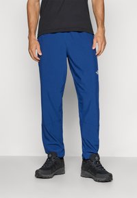 Μπλε εξωτερικό παντελόνι από ελαφρύ ύφασμα. Διαθέτει χαλαρή εφαρμογή, ελαστική μέση και λεπτομέρειες ραφής στα γόνατα.