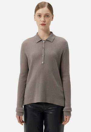 Hellbraunes, geripptes Strickpullover mit Kragen und einer Knopfleiste mit fünf Knöpfen, mit langen Ärmeln und einem leicht abgerundeten Saum, getragen über schwarzen Hosen.