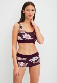 BH en short set in een floral patroon in donker bordeauxrood en crème, met een zachte, rekbare stof en een getailleerd ontwerp.