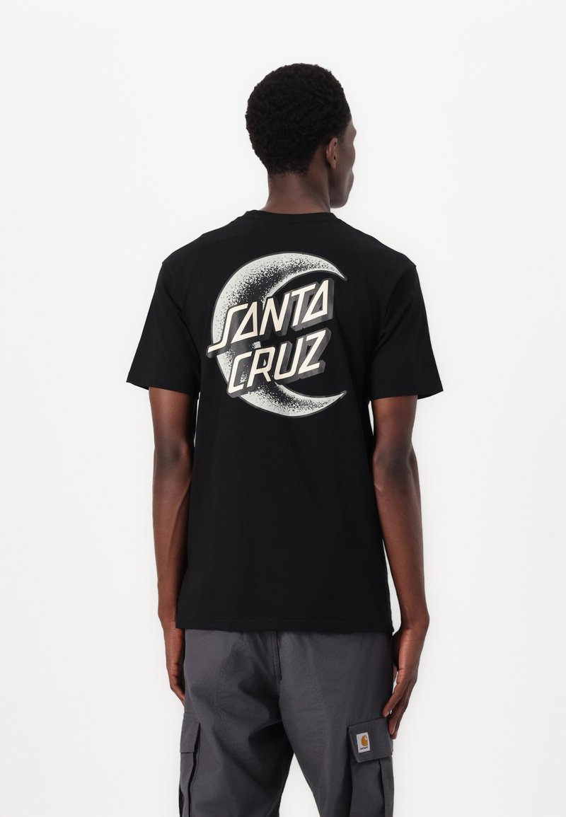 Schwarzes Baumwoll-T-Shirt mit einem großen weißen und silbernen Grafikdesign mit "SANTA CRUZ" und einem Halbmond auf der Rückseite. Normale Passform.