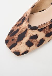 Scarpa piatta con stampa leopardata e punta quadrata, caratterizzata da una tomaia in tessuto morbido, cuciture a contrasto e una soffice fodera beige.