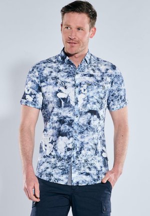 Short-sleeve shirt in blue and white with abstract patterns, button front, and chest pocket. Made of lightweight fabric with a crisp finish.