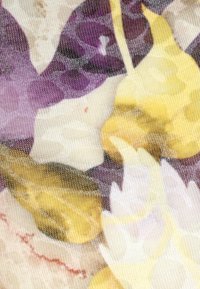 Stoff mit floralem Muster in lila, gelb und weiß. Transparente, leichte Textur mit sanften, fließenden Linien.