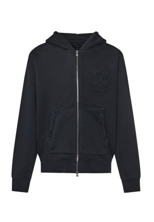 Sudadera con capucha negra con cremallera, bolsillos delanteros y un logo texturizado de manos cruzadas con el texto "AMIRI" en el lado izquierdo del pecho.
