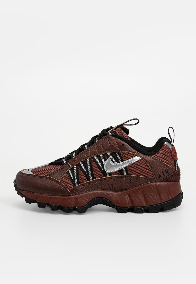 Chaussures Nike avec un dessus en maille marron, des accents noirs, un logo argenté, une semelle intermédiaire marron texturée et une semelle extérieure noire robuste. Motif hexagonal sur les côtés.