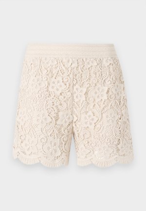 Bermuda in pizzo bianco sporco con motivi floreali, orlo ondulato e vita elastica, caratterizzate da dettagli intricati su tutta la stoffa.