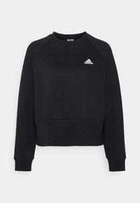 Sudadera de algodón negra con mangas raglán largas, puños y dobladillo acanalados, que presenta un pequeño logo blanco de Adidas en la parte delantera.