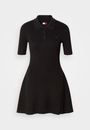 Melns ribots polo kleita, īsas piedurknes, pieguļošs augšdaļa, izplestā svārku daļa. Iespējas ar trīs pogu apdari un mazu logotipa detaļu uz krūtīm.