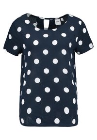 Marinblus med kort ärm och vita prickar. Har rund halsringning och nyckelhål bak. Tillverkad av lätt tyg.