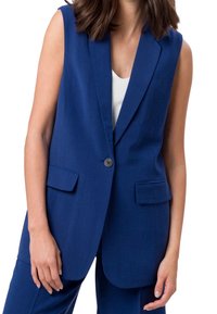 Blazer senza maniche di colore blu navy con rever a punte, chiusura con un bottone singolo e due tasche frontali, realizzato in tessuto testurizzato.