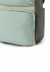 Mochila que presenta una combinación de telas en verde claro y gris oscuro, textura suave y un bolsillo frontal con bordes redondeados.