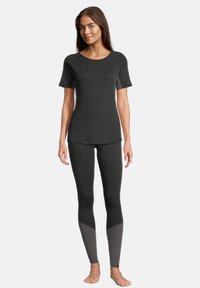 Mørkegrå atletisk top med korte ærmer og matchende leggings, der har en lysere grå sektion ved anklerne, alt sammen lavet af et tekstureret stof.