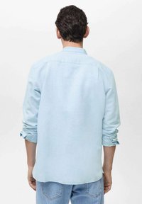 Lichtblauw overhemd met lange mouwen, een ontspannen pasvorm, opgerolde mouwen en een casual kraag, gecombineerd met lichte denim jeans.