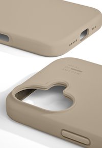 Beige silikone telefonetui med afrundede kanter, udskæring til kamera, logo detaljer præget på overfladen og åbne porte til knapper og opladning.