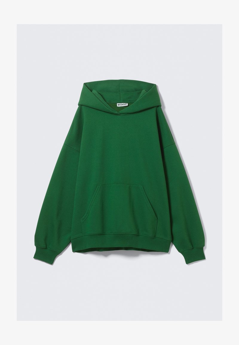 Green oversized hoodie made of soft fabric, featuring a large front pocket, drawstring hood, and ribbed cuffs and hem.