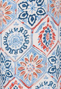Hexagonale patronen op stof in blauw, rood en wit. Bloemachtige en geometrische ontwerpen met gevarieerde vormen en ingewikkelde details.
