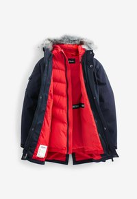 Granatowa zimowa kurtka z kapturem wykończonym futrem, z jasnoczerwoną podszewką i podwójnymi suwakami. Zawiera metkę z marką wewnątrz.