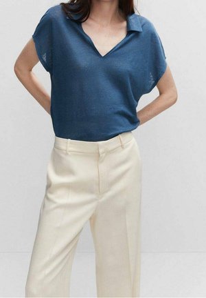 Polo top leggero blu in maglia con scollo a V e maniche corte, abbinato a pantaloni beige su misura con taglio dritto e piega sottile.