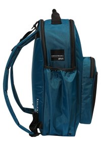 Teal nylon ryggsäck med flera fack, justerbara remmar och en svart logotypetikett. Slät yta och rektangulär form.