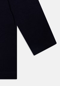 T-shirt à manches longues marine en coton doux, avec une coupe régulière et des poignets finement finis, offrant une texture lisse.