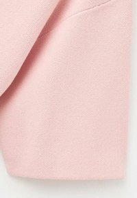 Tessuto texturizzato rosa chiaro con un morbido motivo a maglia. Presenta un bordo liscio e una leggera lucentezza, ideale per un abbigliamento casual.