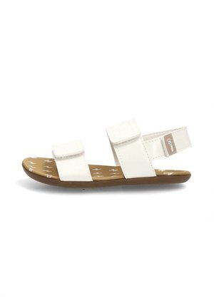 Sandalia blanca con dos tiras ajustables y una suela marrón con un patrón de rayo blanco.