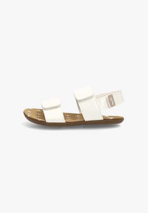 Sandalia blanca con dos tiras ajustables y una suela marrón con un patrón de rayo blanco.