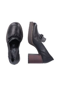 Chaussures noires en cuir avec un talon en bois épais, présentant un détail de chaîne décoratif sur le devant et des coutures contrastantes.