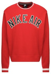 Röd sweatshirt i bomullsblandning, med långa ärmar och ribbade muddarna, med "NIKE AIR" tryckt i fetstil i vita och svarta bokstäver över bröstet.