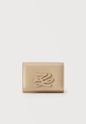 Portefeuille en cuir beige texturé avec logo entrelacé cousu sur le devant, forme rectangulaire, design plié et bords soignés.
