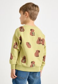 Groene sweater met bruine dierenprints. Lange mouwen, geribbelde boorden en zoom, zachte katoenen stof. Casual pasvorm, met een ronde hals.