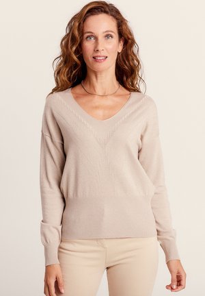 Beige gestrickter Pullover mit V-Ausschnitt, der ein strukturiertes Design und gerippte Bündchen aufweist. Weiches Material mit einem subtilen Schimmereffekt.