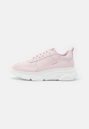 Zapatilla deportiva de color rosa claro con suela blanca gruesa, diseño con cordones y el logotipo "CPNHGN" en el lateral, mostrada de perfil sobre fondo blanco.