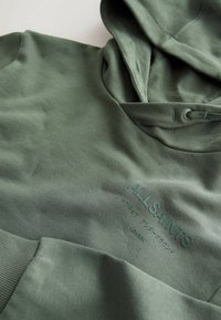 Sweat à capuche vert olive avec poignets côtelés et logo "ALLSAINTS" en relief sur le devant.