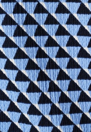 Motif diagonal de triangles noirs et bleu clair alternés avec une texture en maille ondulée sur une surface en tissu doux.