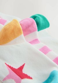Chaussettes colorées avec une base blanche et des accents roses et verts, des rayures et un motif d'étoiles rouges. Fabriquées en matériau tricoté côtelé.