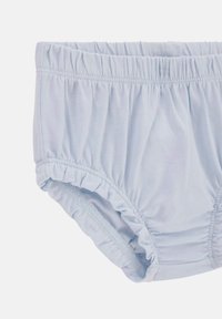 Shorts en coton bleu clair avec une taille élastiquée et des accents de volants sur les bords. Texture douce, conçue pour le confort et la facilité de port.