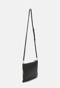 Bolso bandolera de cuero negro con textura suave, forma rectangular, correa ajustable y cremallera en tono dorado.
