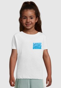 Hvid bomulds t-shirt med blå tekstureret "SHINE BRIGHT" grafik på brystet. Klassisk pasform, korte ærmer og rund halsudskæring.