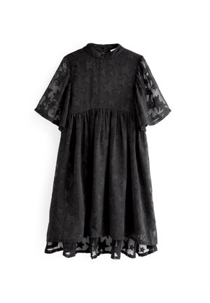 Czarna sukienka z krótkimi, rozkloszowanymi rękawami, z teksturowanym motywem gwiazd i marszczonym dołem. Przezroczysta warstwa wierzchnia z kontrastującym wzorem na brzegu.