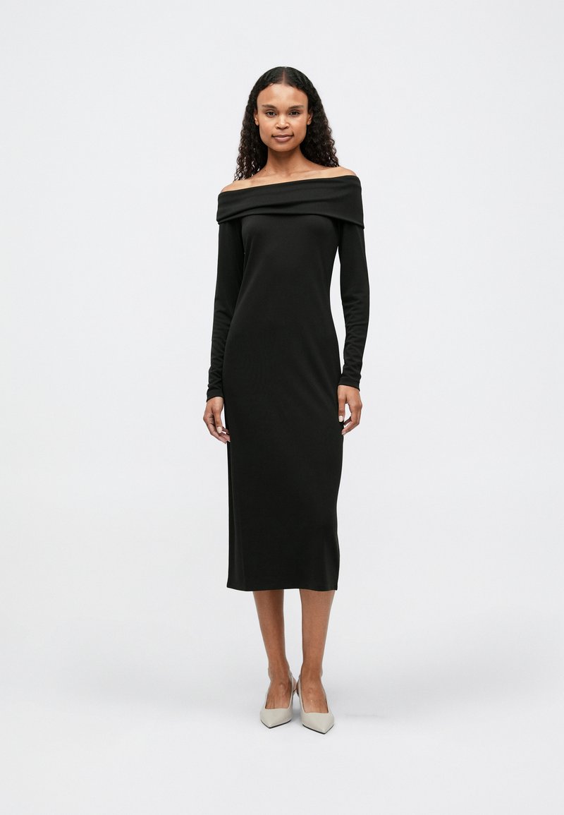 Μαύρο φόρεμα σε στυλ off-the-shoulder κατασκευασμένο από μαλακό ύφασμα, με μακριά μανίκια και εφαρμοστή σιλουέτα, που καταλήγει κάτω από το γόνατο. Απλός σχεδιασμός.