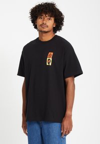 Black cotton t-shirt featuring a square graphic design with orange, yellow, and black colors on the chest. Short sleeves, relaxed fit.