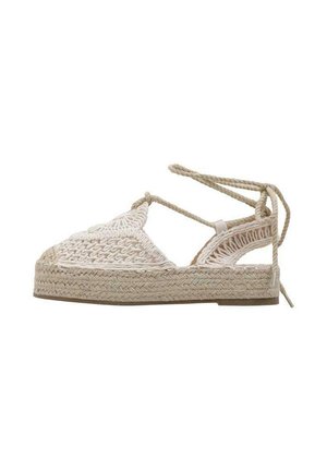 Sandale espadrille tissée beige avec bout fermé, côtés découpés, semelle plate tressée et fermeture à nouer autour de la cheville.