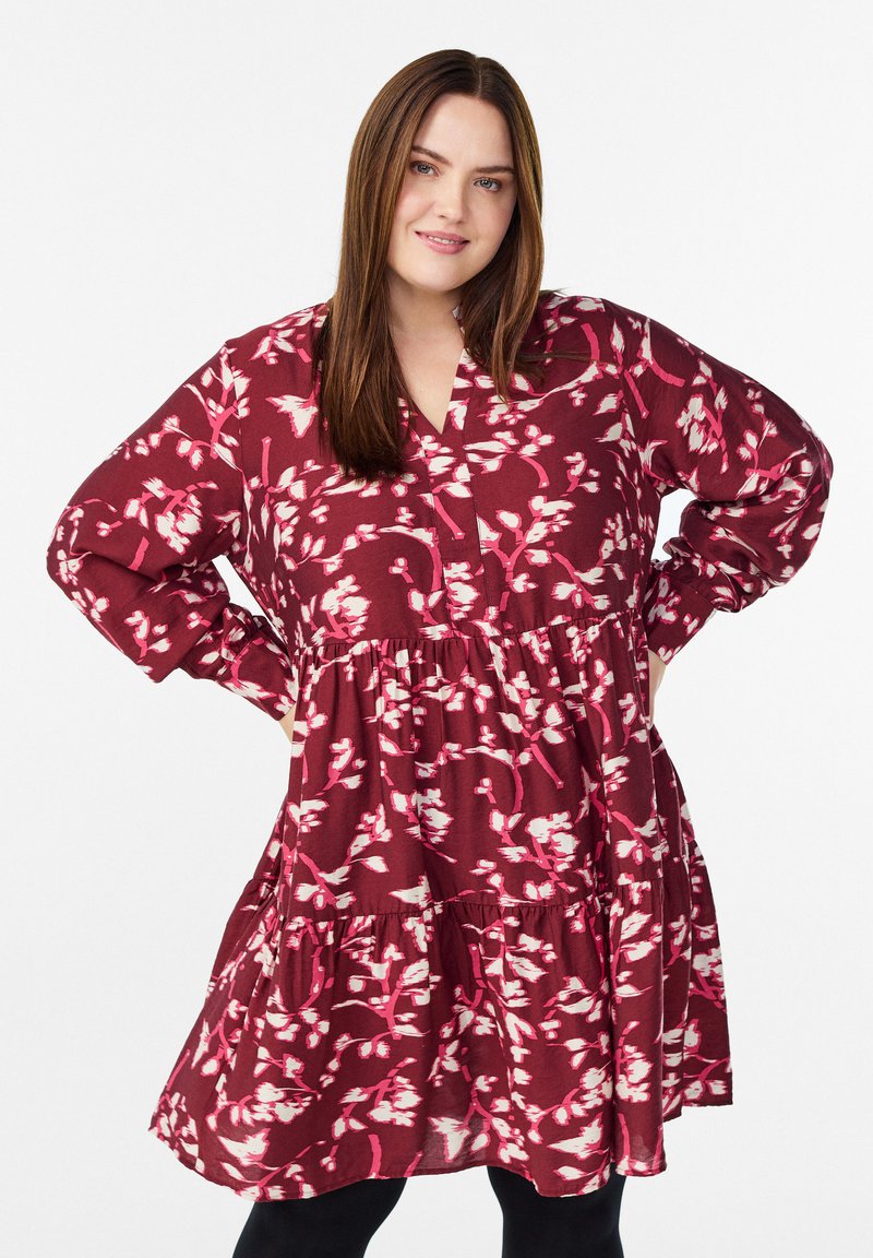 Bordo gėlėmis print su rožinėmis detalėmis suknelė, turinti V formos iškirptę, ilgas rankoves ir sluoksniuotą sijoną. Lygi audinio tekstūra.