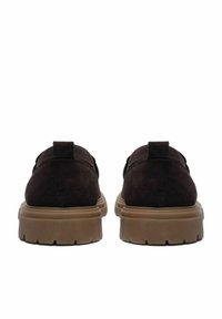 Braune Wildlederschuhe mit einer dicken, hellbraunen Gummisohle, die eine abgerundete Form und eine kleine Fersenschlaufe für einfaches Anziehen haben.