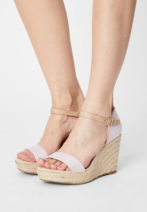 Keilabsätze mit einem beige geflochtenen Sockel, ausgestattet mit rosa und weißen gestreiften Stoffriemen und einem Schnallenverschluss am Knöchel.