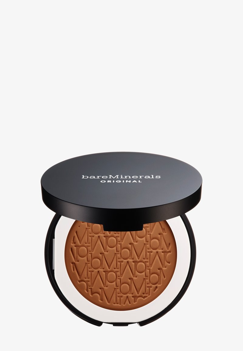 Polvo compacto en un estuche circular negro con acentos en blanco. El polvo es de color bronceado, con un patrón de logo en relieve en la superficie.