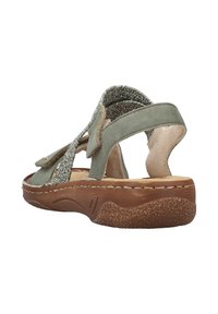Sandale verte avec accent en textile tissé, brides en daim souple et semelle en caoutchouc brun texturé. Design ouvert à l'arrière pour une meilleure respirabilité.