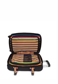 Maleta negra con un interior de rayas coloridas. Cuenta con un asa de plástico, cremallera y un bolsillo de malla. Diseño rectangular y de tamaño considerable.