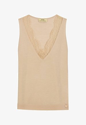 Beżowy bezrękawnik z dzianiny o głębokim dekolcie w kształcie litery V, ozdobiony delikatną koronką i małą okrągłą metalową metką z logo przy krawędzi.